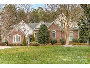 Charming brick home with manicured lawn and mature trees offers timeless curb appeal at 125 Whiterock Dr, Mount Holly, NC 28120