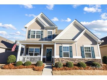 Charming two-story home with a welcoming front porch, manicured landscaping, and a combination of siding and stone accents at 136 Kingston Dr, Locust, NC 28097