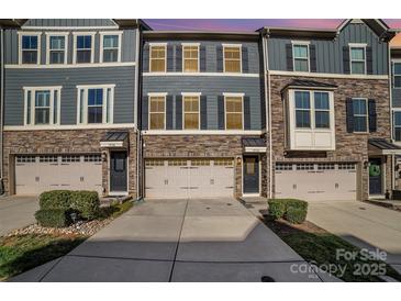 Charming townhome featuring a stone facade, three stories, and a one car garage at 1932 Catkin Ln, Charlotte, NC 28205