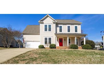 Charming two-story home features a welcoming front porch, bright red door, and a well-manicured lawn at 2010 Hollyhedge Ln, Indian Trail, NC 28079