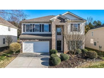 Charming two-story home featuring a brick facade, two-car garage, and well-maintained landscaping at 2017 Bridleside Dr, Indian Trail, NC 28079