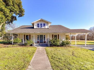 Charming home with a long, covered front porch and a matching covered carport at 214 W Elm St, Wingate, NC 28174