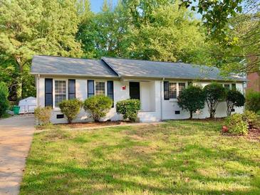 Charming single-story home featuring a brick facade, manicured lawn, and mature trees at 2314 Knickerbocker Dr, Charlotte, NC 28212