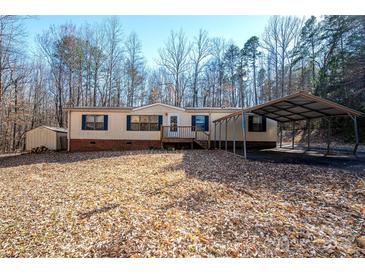 A cozy single-story home with a carport and a small storage shed nestled among the trees at 237 Creekstone Ln, York, SC 29745
