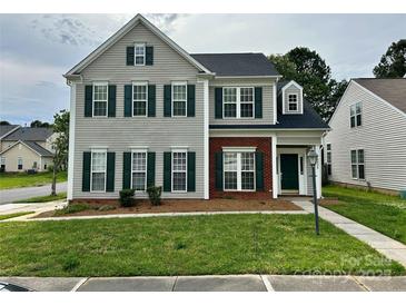 Two-story home with gray siding, brick accents, and complementary green shutters and front door at 5905 Waverly Lynn Ln, Charlotte, NC 28269