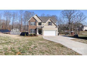 Charming two-story home featuring brick accents, neutral siding, and an attached two-car garage at 8822 Crape Myrtle Dr, Stanfield, NC 28163