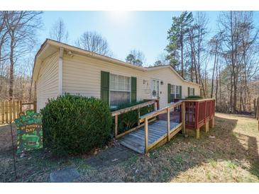 Charming single-story home with wooden deck, green shutters, and neatly kept landscaping at 1049 Ramsey St, Stanley, NC 28164