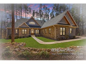 Charming stone and siding home with manicured lawn and inviting walkway to a double door entry at 1547 Sunset Pointe Dr, Salisbury, NC 28146