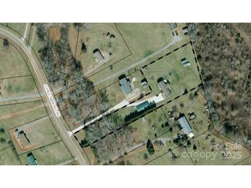 Expansive property featuring multiple structures, a long driveway, and mature trees, offering privacy and potential at 231 John E Randall Rd, Shelby, NC 28152