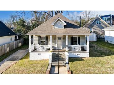 Charming home featuring a decorative front porch with white railings and brick foundation at 314 S Bruns Ave, Charlotte, NC 28208