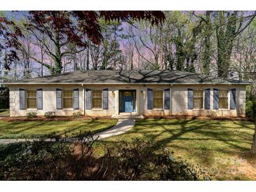 Charming one-story home featuring a brick facade, blue shutters, a well-manicured lawn, and a welcoming blue front door at 800 River Oaks Ln, Charlotte, NC 28226