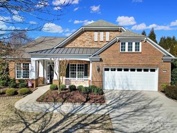 Charming brick home with a stone facade, manicured landscaping, and a two-car garage at 9332 Whistling Straits Dr, Fort Mill, SC 29707