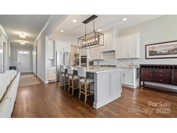 Open-concept kitchen featuring a spacious island with bar seating, modern appliances, and stylish cabinetry at 182 Walking Horse Trl, Davidson, NC 28036