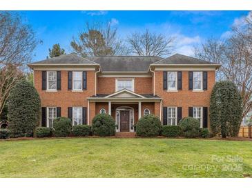 Charming two-story brick home with a well-manicured lawn and mature landscaping in a suburban setting at 700 Queen Charlottes Ct, Charlotte, NC 28211