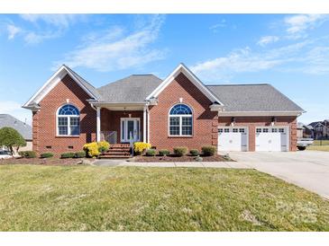 Charming brick home featuring a manicured lawn, attached two-car garage, and covered front porch at 9016 Heather Trce, Gastonia, NC 28056