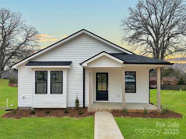 Charming remodeled single story home with black framed windows, a covered porch, and a well manicured lawn at 141 Ark St, Kings Mountain, NC 28086