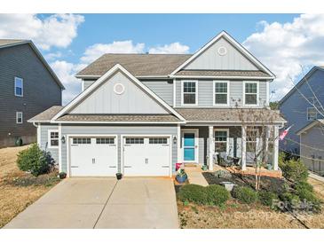 Beautiful two-story home with a two-car garage and front porch, enhanced by a bright blue door and attractive landscaping at 1426 Whitman Ct, York, SC 29745