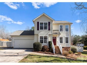 Charming two-story home features a well-maintained lawn and a welcoming front entrance with a red door at 159 Creekwood Dr, Mooresville, NC 28117