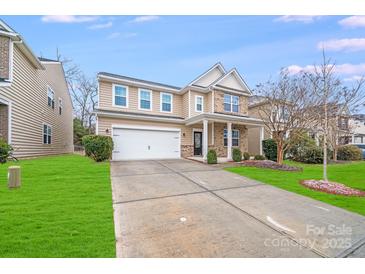Beautiful home showcasing a manicured front lawn, two-car garage, and a welcoming entrance at 2679 Southern Trace Dr, Waxhaw, NC 28173