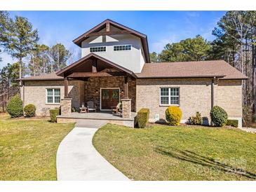Inviting front exterior featuring a beautiful stone facade, well-manicured lawn, and a charming walkway at 4616 Gold Finch Dr, Denver, NC 28037