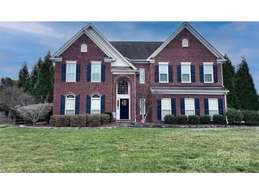 Charming two-story brick home featuring a well-manicured lawn and complementary dark shutters at 6115 Lostgate Ln, Waxhaw, NC 28173