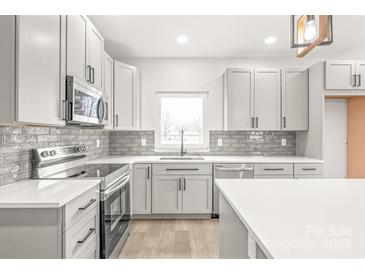 Modern kitchen featuring stainless steel appliances, granite countertops, shaker cabinets, and subway tile backsplash at 6535 Fisher Farm Nw Ln, Concord, NC 28027