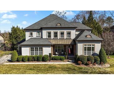 Elegant two-story home featuring a manicured lawn, stone accents, and a welcoming front porch at 7205 Yellowhorn Trl, Waxhaw, NC 28173