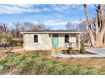 Charming bungalow with a covered front porch and lovely landscaping and a walkway to the driveway at 1061 Gaither Nw Pl, Concord, NC 28027