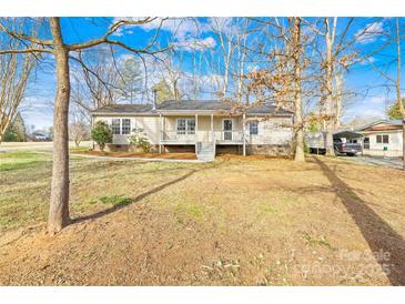 Charming single-story home with a front porch, mature trees, and well-maintained landscaping at 120 Roger Dr, Statesville, NC 28625
