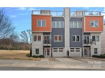 Modern townhome with rooftop decks, attached garage, and colorful orange and gray exterior at 1522 Peridoe Point Ln, Charlotte, NC 28206