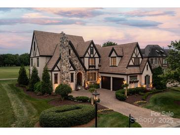 Charming Tudor-style home boasting stone accents, a brick driveway, and lush landscaping at 314 Royal Crescent Ln, Waxhaw, NC 28173