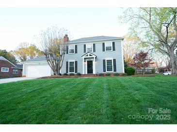 Charming two-story home with a well-manicured lawn, attached garage, and inviting front entrance at 5925 Carmel Station Ave, Charlotte, NC 28226