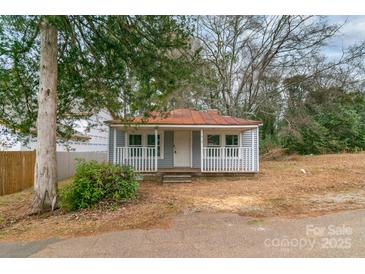 Charming home features a cozy front porch with a welcoming facade and a quaint, well-kept yard at 609 Cedar St, Wadesboro, NC 28170