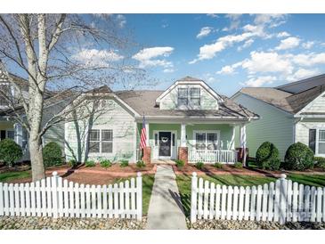 Charming one-story home with a welcoming front porch, a white picket fence, and beautiful landscaping at 7037 Ladys Secret Dr, Indian Trail, NC 28079