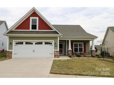 Charming home with a two-car garage, red accents, stone veneer and a well-maintained lawn at 822 Wisteria Way, Salisbury, NC 28146