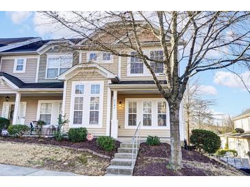Charming townhome featuring neutral siding, multi-pane windows, and a welcoming front entrance at 9741 Turning Wheel Dr, Charlotte, NC 28214