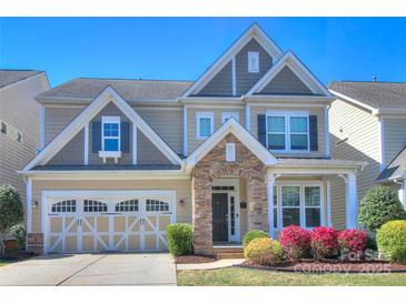 Charming two-story home with stone accents, inviting front porch, and attached two car garage at 1012 Equipoise Dr, Indian Trail, NC 28079