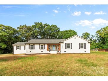 Charming white home with a welcoming blue door and well-manicured lawn on a sunny day at 1131 Doby Ct, Fort Mill, SC 29715