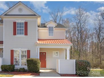 Charming townhome featuring red shutters, a cozy front porch with a vibrant red door, and fresh landscaping at 1751 Holliford Ct, Charlotte, NC 28215