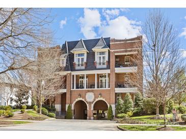 Elegant brick building with arched entryway and balconies, set against a bright sky at 2251 Selwyn Ave # 201, Charlotte, NC 28207