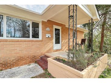 Inviting front porch of brick home with tasteful landscaping and charming architectural details at 2548 Milton Ave, Gastonia, NC 28052