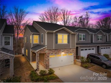 Charming two-story home with stone accents and a spacious two-car garage on a cloudy day at 3512 Auburn Curb Rd, Charlotte, NC 28217