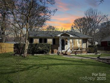 Charming single-story home with a well-manicured front lawn and a welcoming porch, perfect for enjoying peaceful evenings at 4201 Winedale Ln, Charlotte, NC 28205