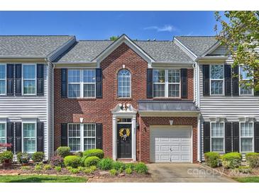 Charming brick townhome featuring an attached garage, black shutters, and a landscaped front yard at 530 Pate Dr, Fort Mill, SC 29715