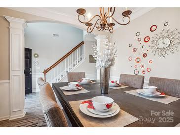 Dining room with wood table, seating for six, decorative wall art, and chandelier at 558 Rough Hewn Ln, Rock Hill, SC 29730