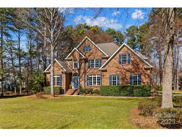 Charming two-story brick home featuring mature trees and a well-manicured lawn at 109 Gannett Dr, Mooresville, NC 28117