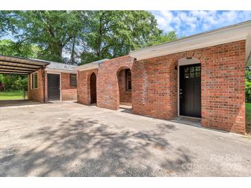 Charming red brick home with arched doorway, and a covered carport at 1125 Mcdow Dr, Rock Hill, SC 29732