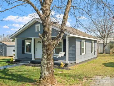 Quaint home with a covered front porch, featuring black shutters and a porch swing at 125 Ashe St, Gastonia, NC 28056
