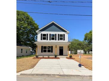 Charming two-story home with a covered front porch and a well-manicured yard at 1308 Jay Ave, Gastonia, NC 28052