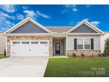 Charming single-story home featuring stone accents, a two-car garage, and a well-manicured lawn at 164 Wembury Ln, Troutman, NC 28166